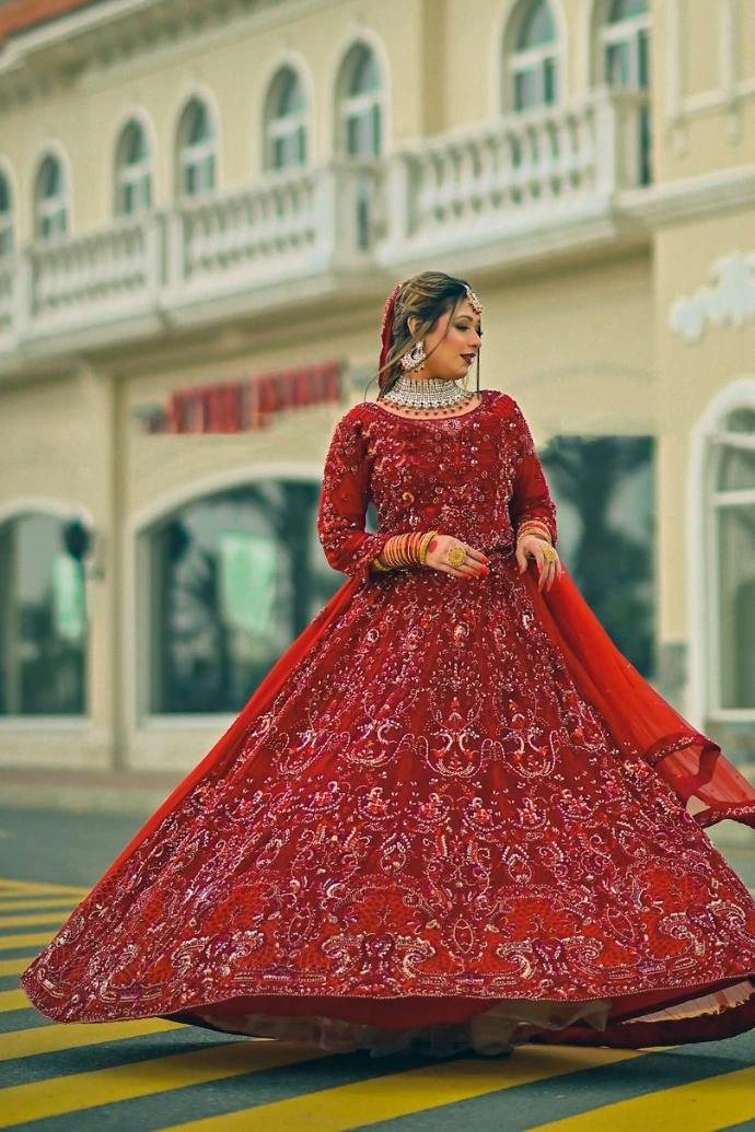 a woman in a red dress standing in front of a building